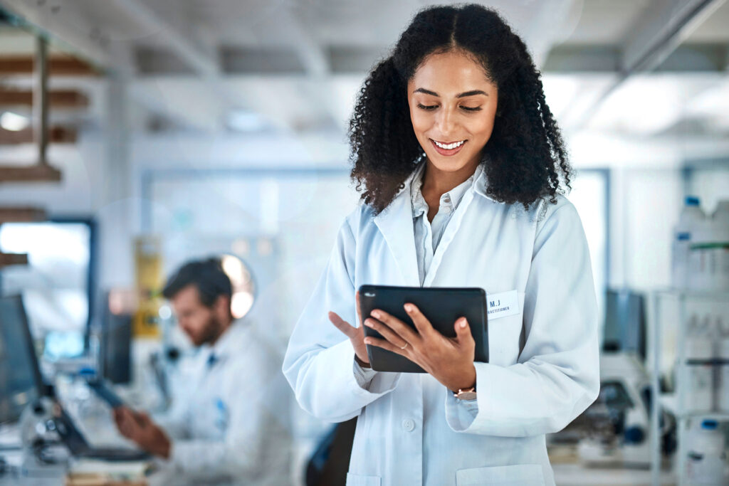 Science, research and black woman with tablet, smile and internet in laboratory with medical data. Healthcare, pharmaceutical innovation and scientist, technology and reading email, website or result.